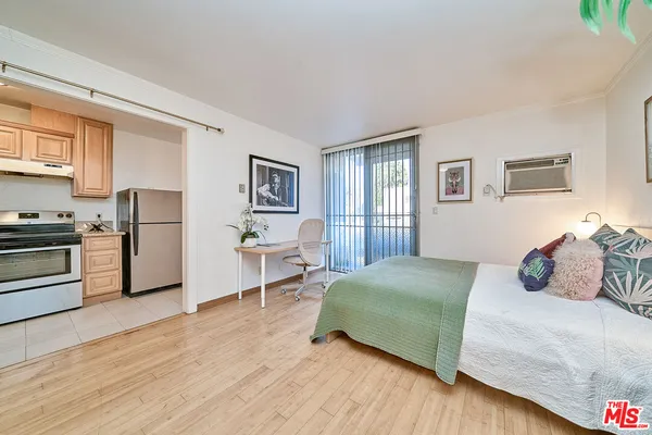a bedroom with a bed and a refrigerator
