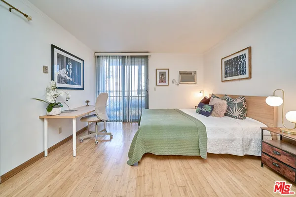 a bedroom with a bed and a wooden floor