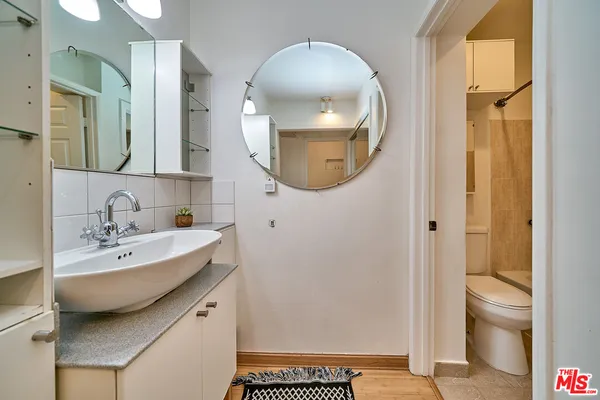a bathroom with a sink a toilet and a mirror