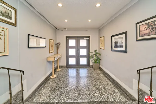 a view of a hallway with wooden floor and a living room