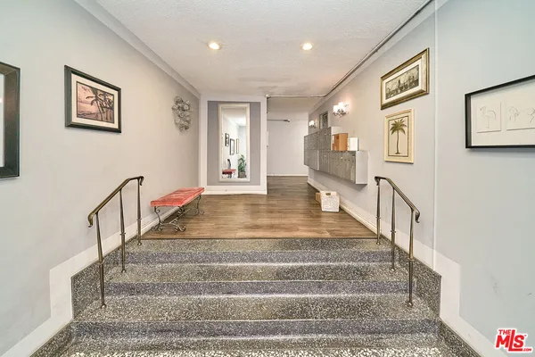 a view of staircase with lots of frames on wall and a window