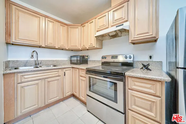 a kitchen with stainless steel appliances granite countertop white cabinets stove a sink and dishwasher