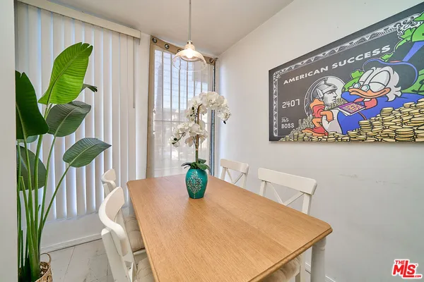 a dining room with furniture and a potted plant