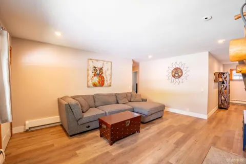 a living room with furniture and a wooden floor