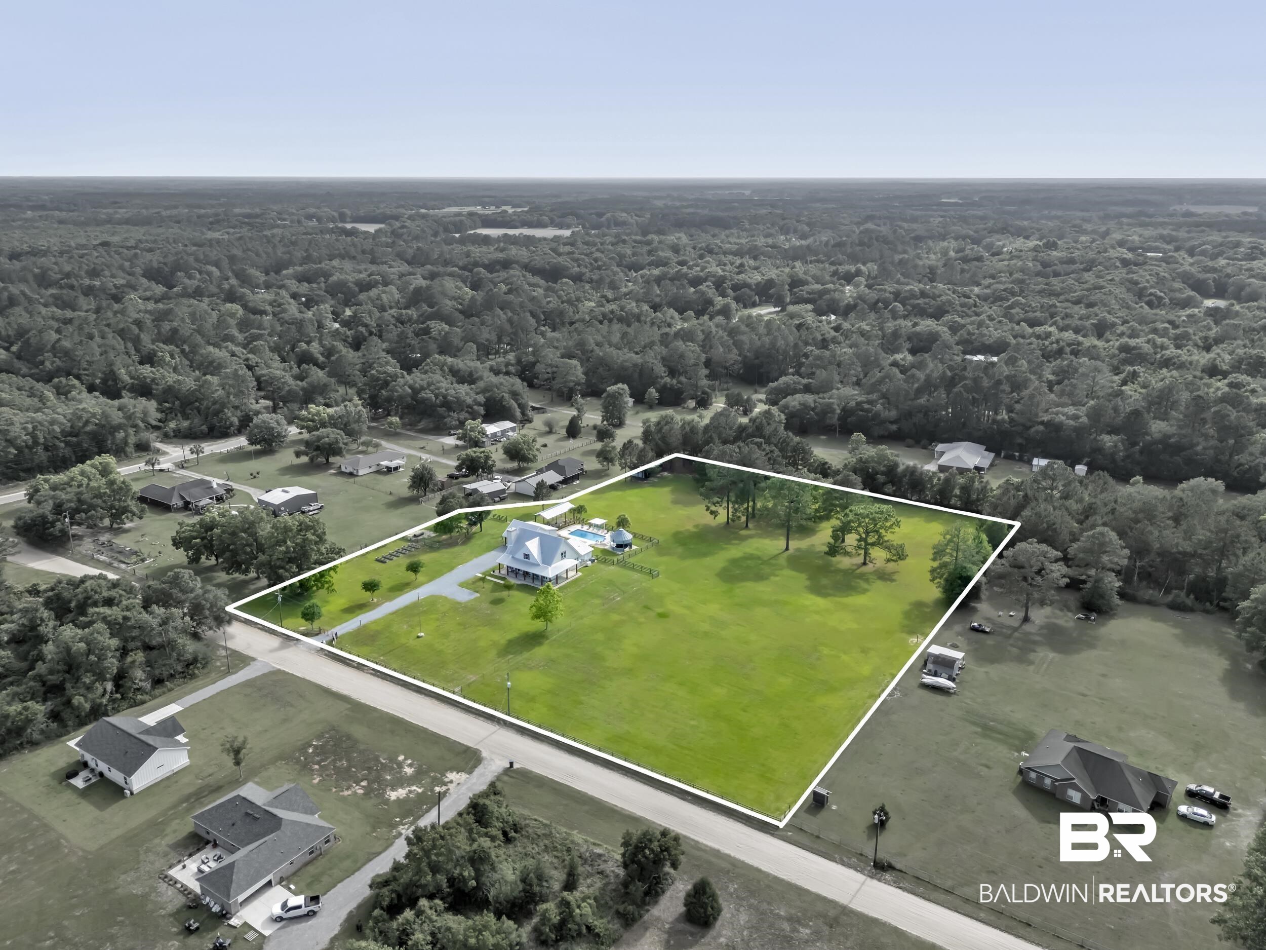 6576 Ranch Loop Road East Grand Bay, AL 36541 - Photo 34 of 39 Expansive lot featuring a single-family residence with a light-colored exterior, an in-ground pool, a lengthy driveway, and mature trees