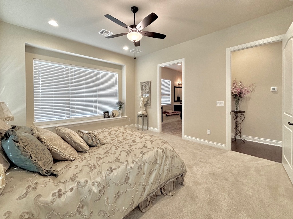 820 Desaix Drive Georgetown, TX 78628 - Photo 20 of 35 a spacious bedroom with a large bed and a chandelier
