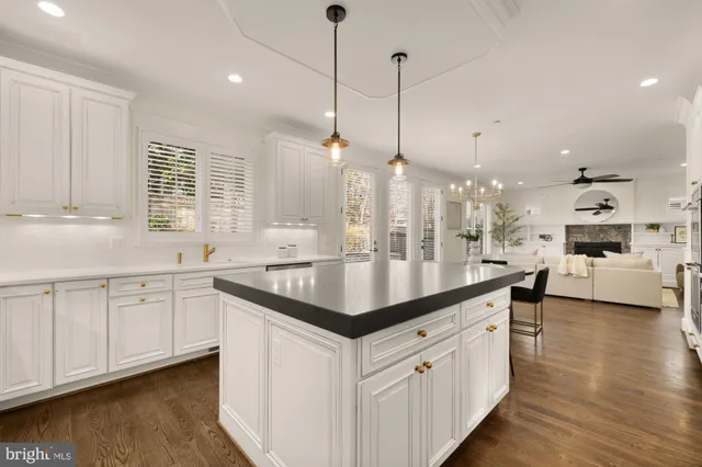 a kitchen with stainless steel appliances kitchen island granite countertop a stove a table and chairs