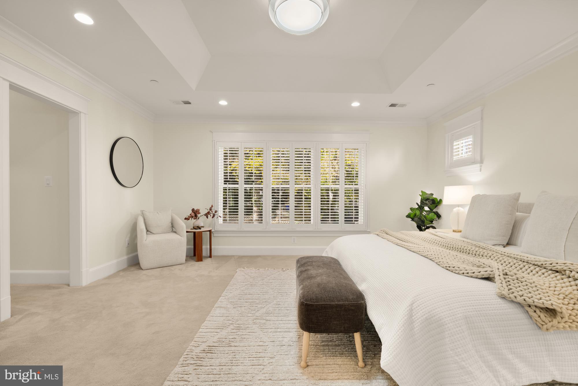 4609 Glenbrook Parkway Bethesda, MD 20814 - Photo 27 of 62 a spacious bedroom with a large bed and a chandelier