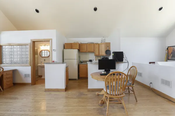 a kitchen with a refrigerator a stove a sink dishwasher and wooden cabinets with wooden floor