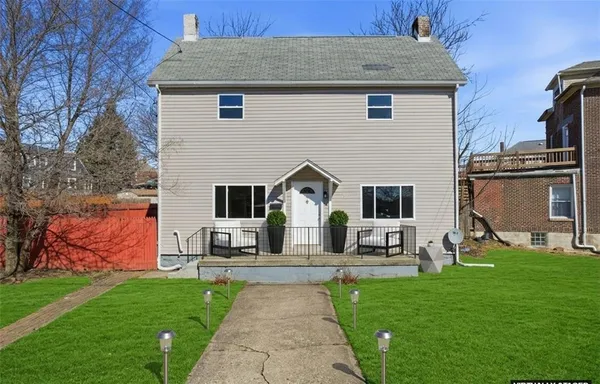 a front view of house with yard and green space
