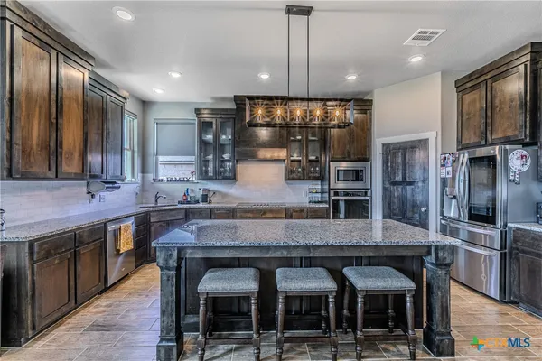 a large kitchen with a table and chairs