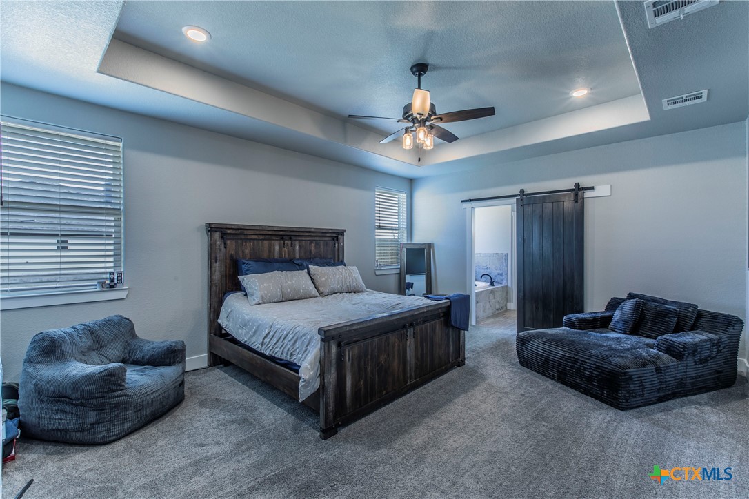 8323 Torrente Drive Temple, TX 76504 - Photo 15 of 30 a spacious bedroom with a bed a couch and a chandelier