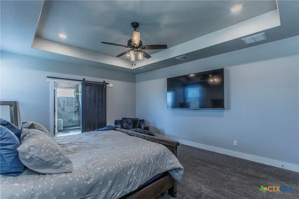 a bedroom with a large bed and a flat screen tv