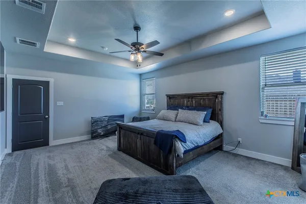 a spacious bedroom with a bed and a ceiling fan