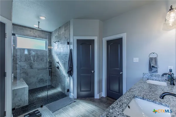 a bathroom with a sink a toilet and shower