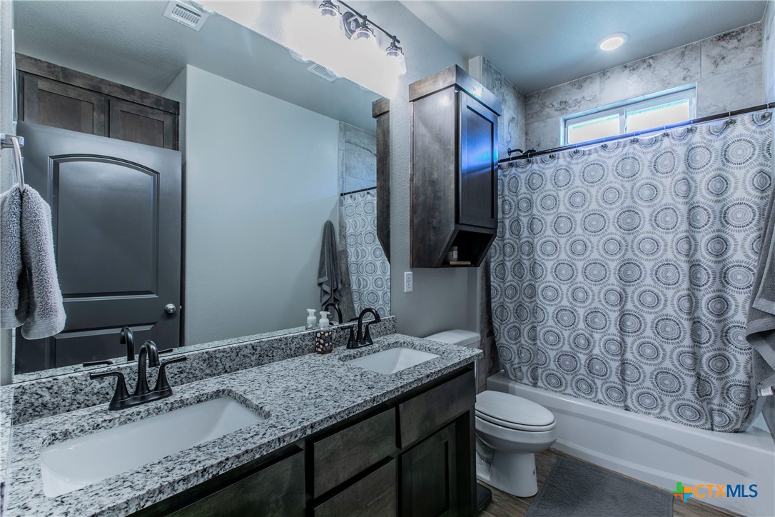 8323 Torrente Drive Temple, TX 76504 - Photo 28 of 30 a bathroom with a granite countertop sink toilet and shower