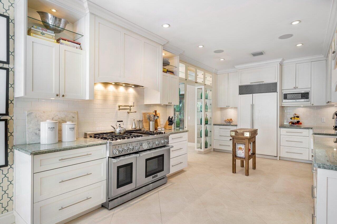 265 List Road Palm Beach, FL 33480 - Photo 13 of 38 a kitchen with white cabinets and white appliances