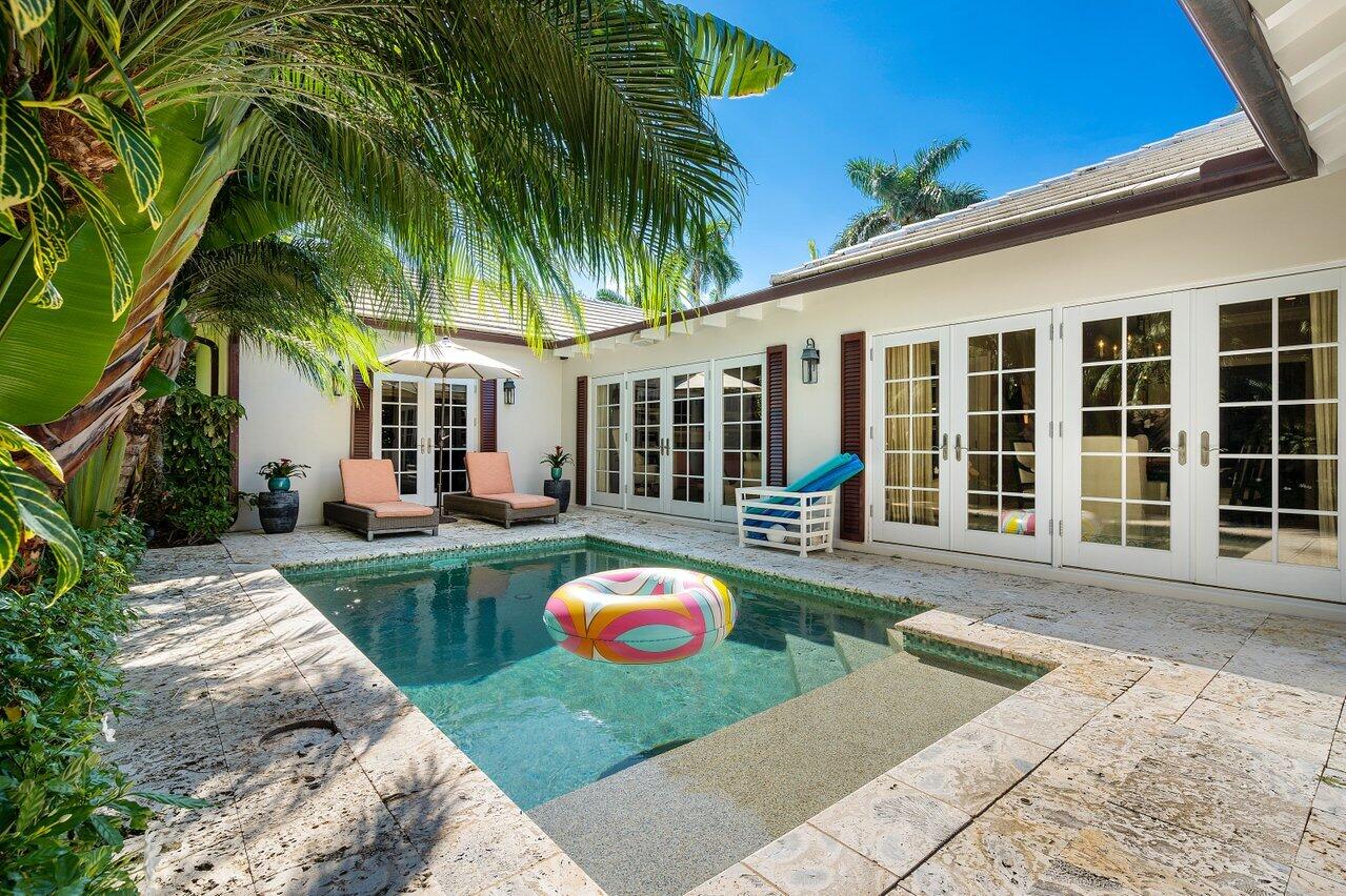 265 List Road Palm Beach, FL 33480 - Photo 33 of 38 a front view of a house with swimming pool patio and garden