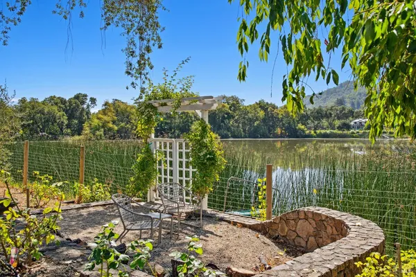 an aerial view of residential house with outdoor space and trees all around