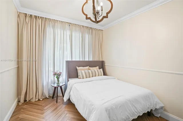 a bedroom with a bed and a chandelier