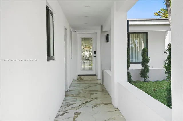 a view of a hallway with wooden floor and a yard