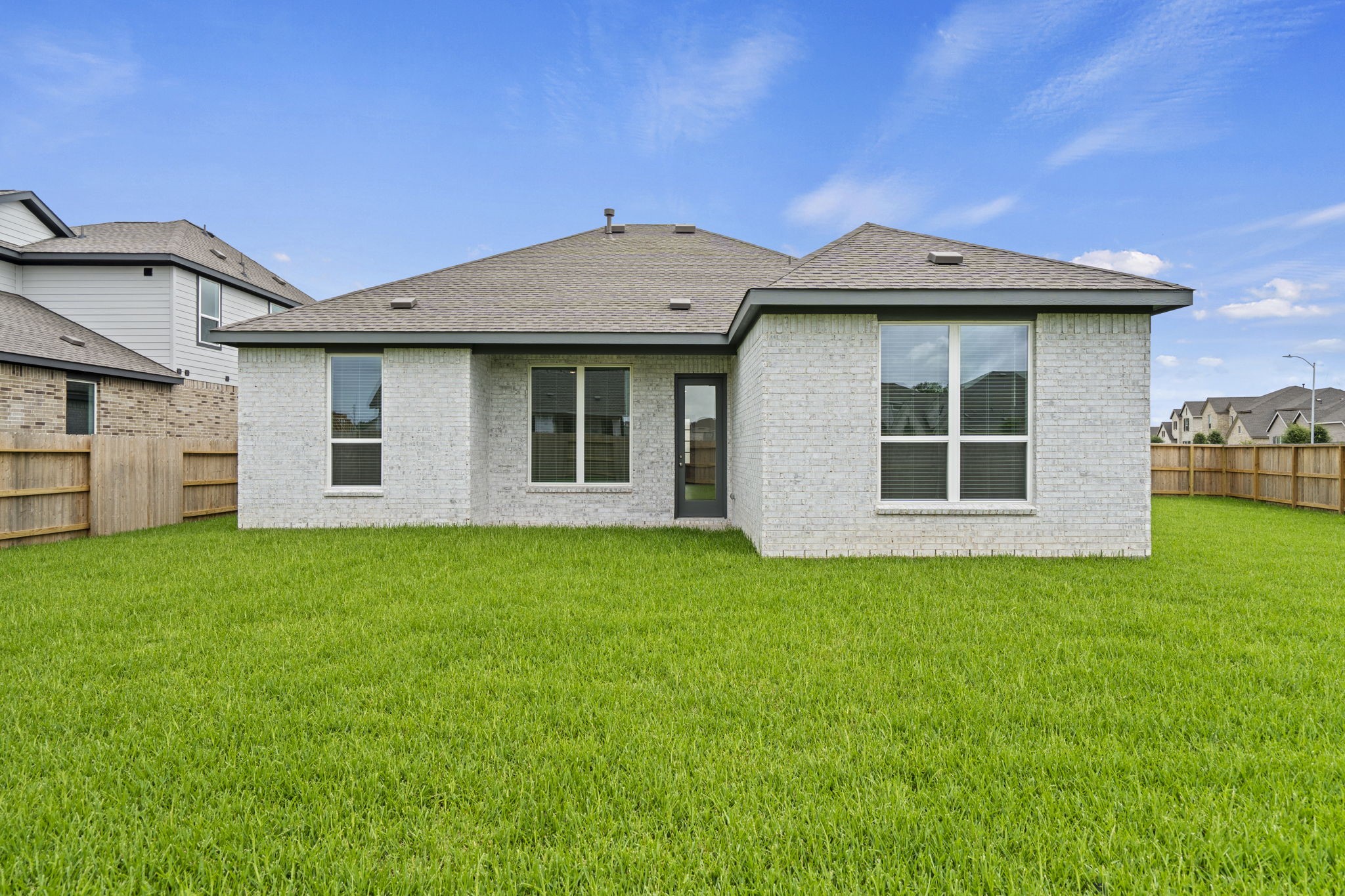 2720 Grove Crest Drive Rosenberg, TX 77469 - Photo 31 of 32 Beautiful rear elevation with contemporary brick exterior, covered patio access, and a spacious fully fenced backyard ready for outdoor enjoyment.