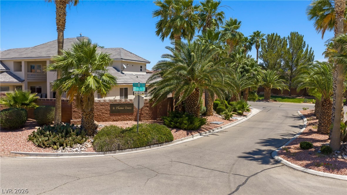 1141 Thomas Bay Circle Logandale, NV 89021 - Photo 2 of 16 This serene neighborhood entry welcomes residents with lush landscaping and vibrant greenery.