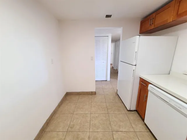 a view of a storage in a utility room with a refrigerator