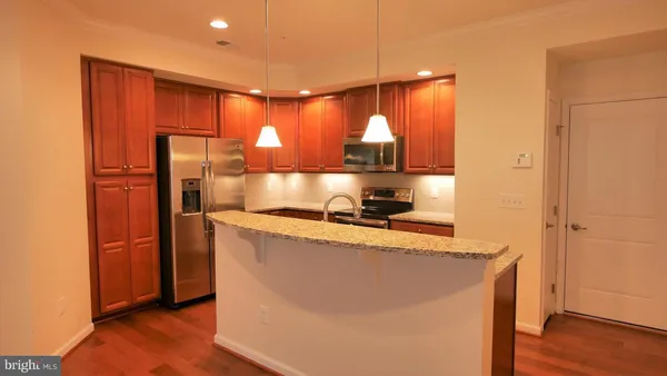 a kitchen with stainless steel appliances granite countertop a refrigerator a sink and a stove