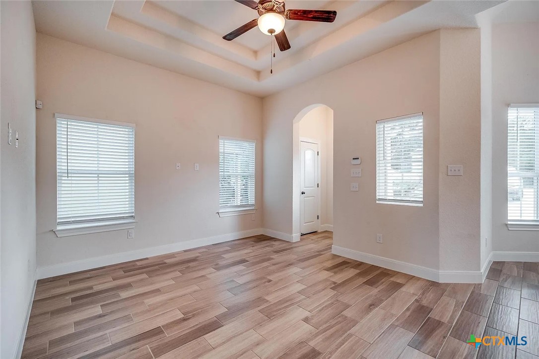 3133 Puter Creek Road, Unit B Spring Branch, TX 78070 - Photo 12 of 19 an empty room with wooden floor chandelier fan and windows