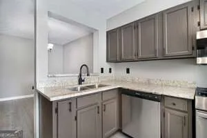 a kitchen with stainless steel appliances granite countertop a sink dishwasher and cabinets with wooden floor