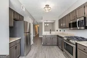 a kitchen with stainless steel appliances granite countertop a stove refrigerator sink and microwave