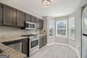 a kitchen with stainless steel appliances granite countertop a stove a sink and a microwave