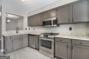 a kitchen with cabinets appliances a sink and a counter top space