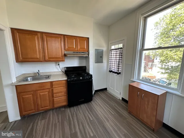 a kitchen with granite countertop wooden floors and sink