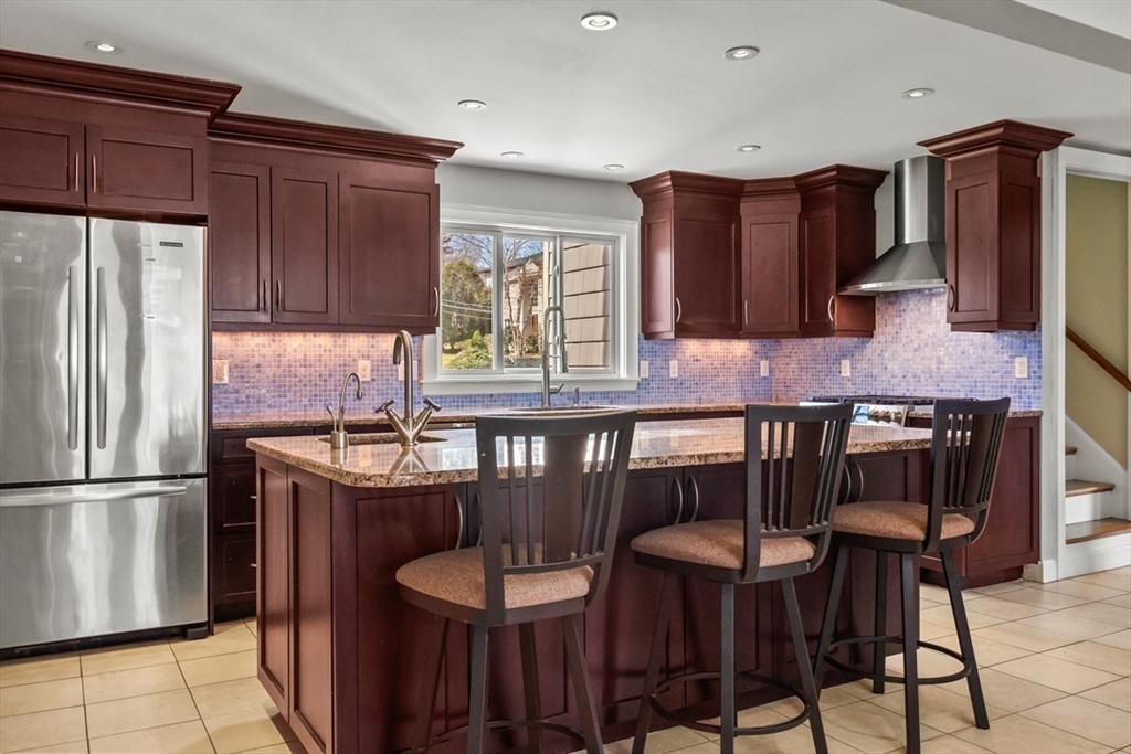 55 Wheeler Road Newton, MA 02459 - Photo 4 of 22 a kitchen with granite countertop a table chairs stove refrigerator and cabinets