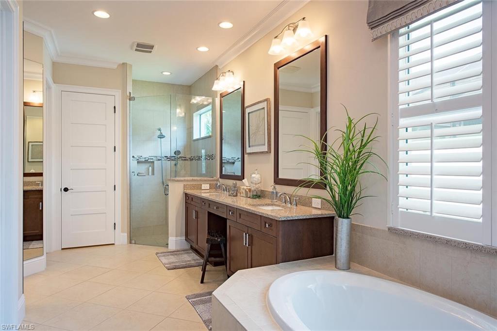 5098 Andros Drive Naples, FL 34113 - Photo 12 of 22 a bathroom with a sink a toilet and a large mirror