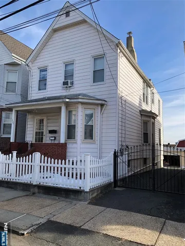 a view of a house with wooden fence