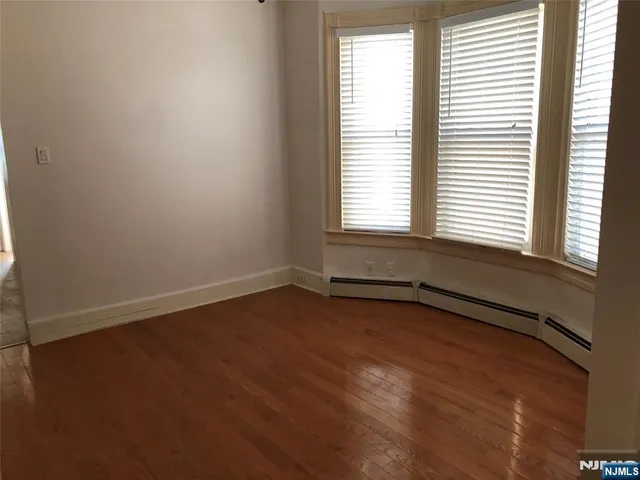 an empty room with wooden floor and a window