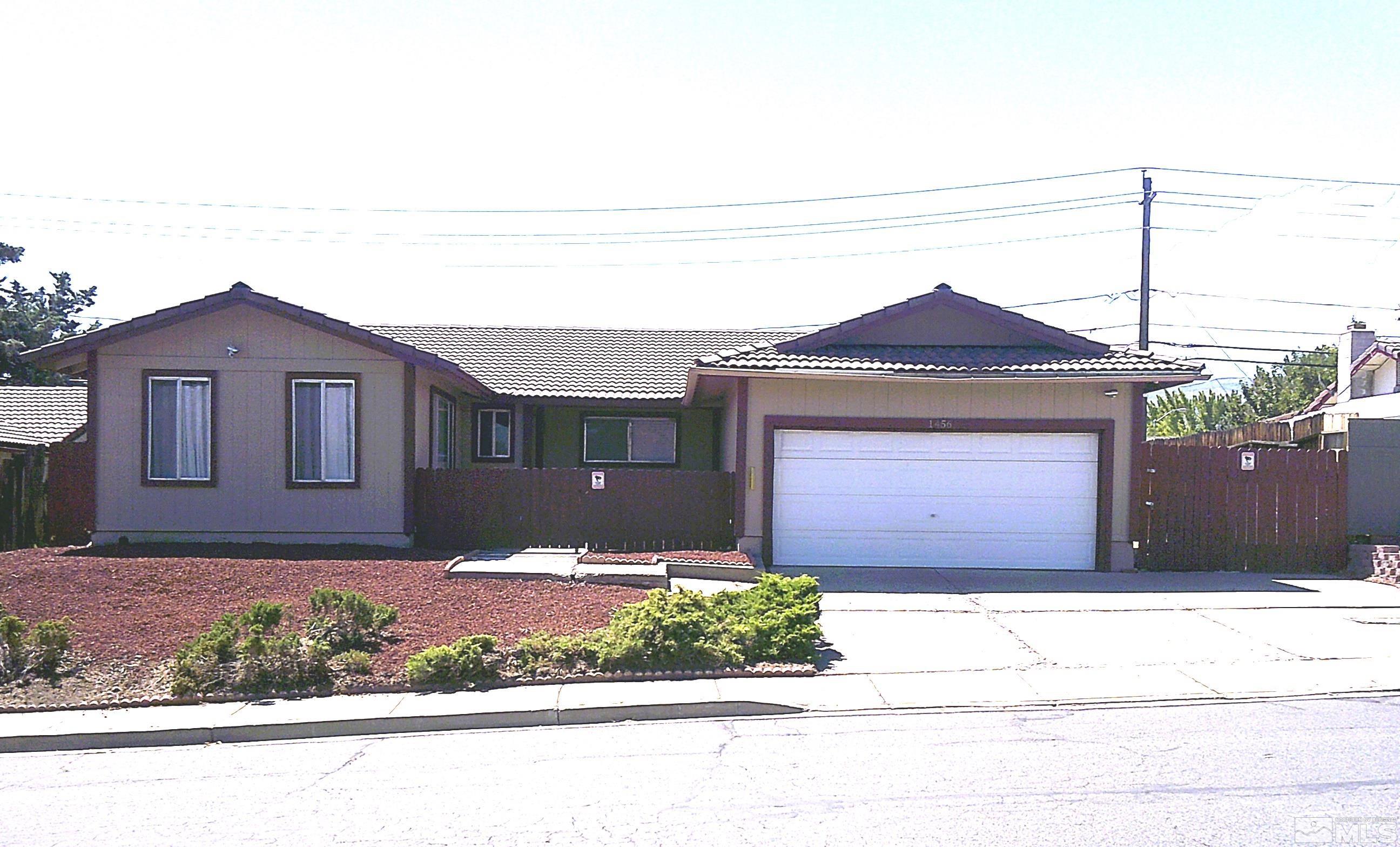 1456 Frontier Street Reno, NV 89503 - Photo 1 of 11 a front view of a house with a yard and garage