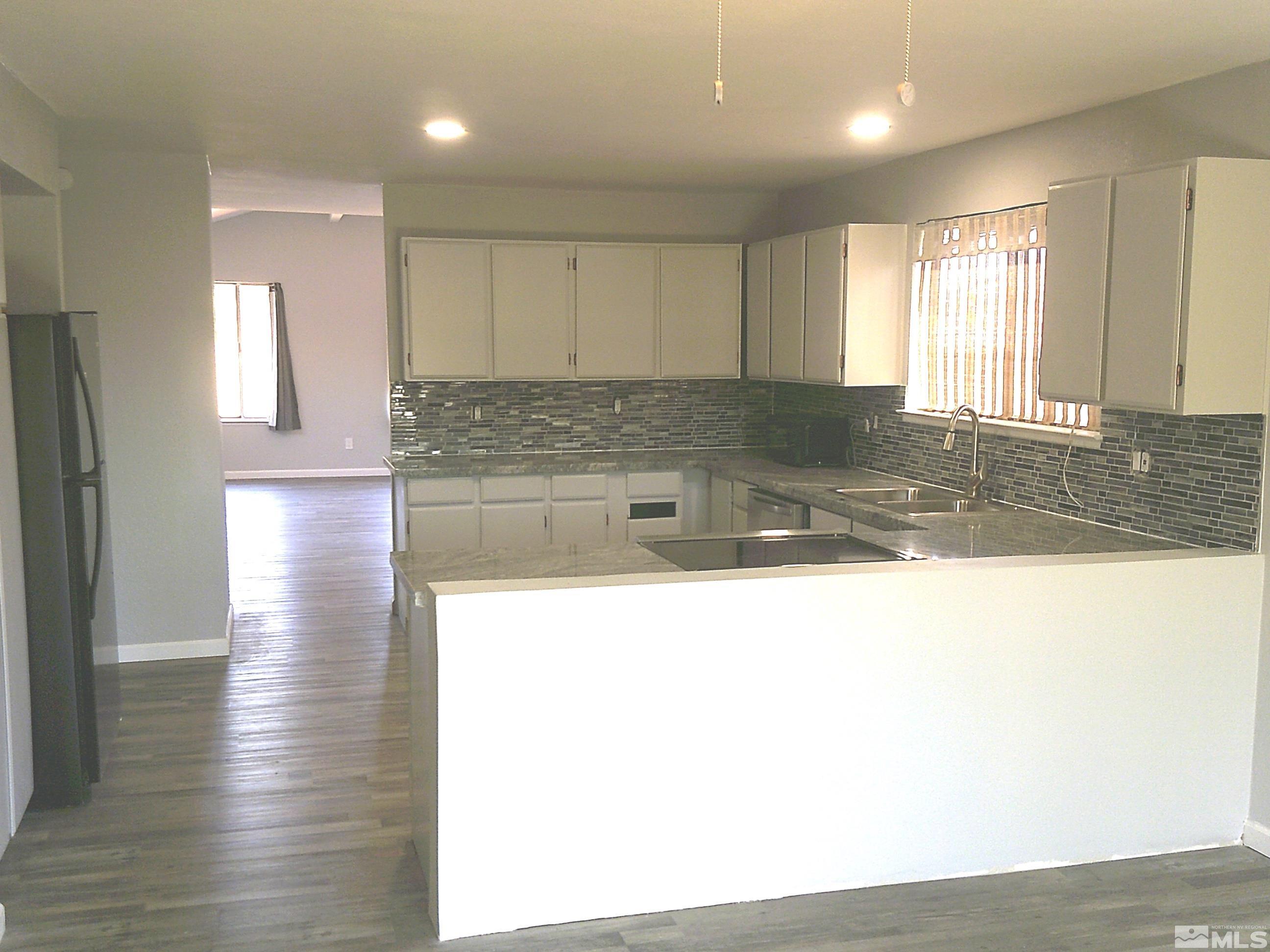 1456 Frontier Street Reno, NV 89503 - Photo 4 of 11 a view of a kitchen with kitchen island a sink wooden floor and glass window