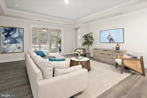 a kitchen with a refrigerator and white cabinets with wooden floor