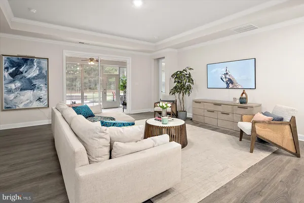 a kitchen with a refrigerator and white cabinets with wooden floor
