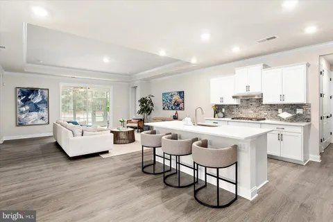a living room with furniture a table and kitchen view