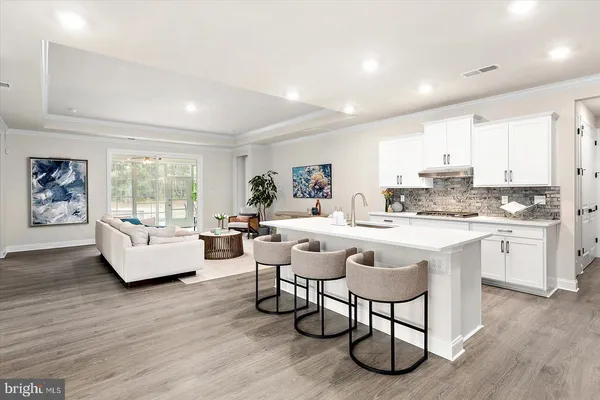 a living room with furniture a table and kitchen view