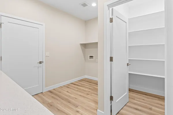 a view of a hallway with wooden floor and closet