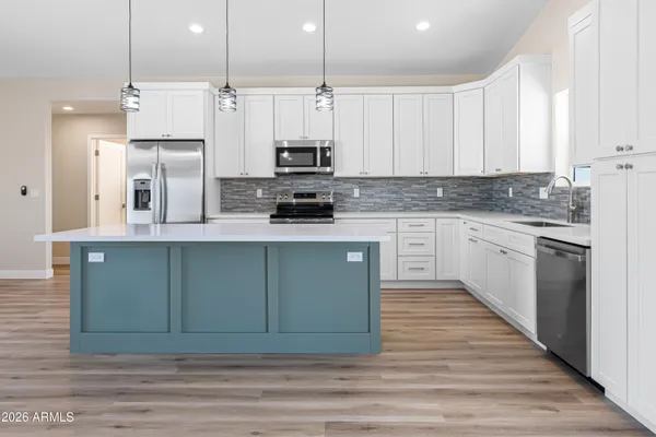 a kitchen with stainless steel appliances granite countertop a stove a sink and a refrigerator