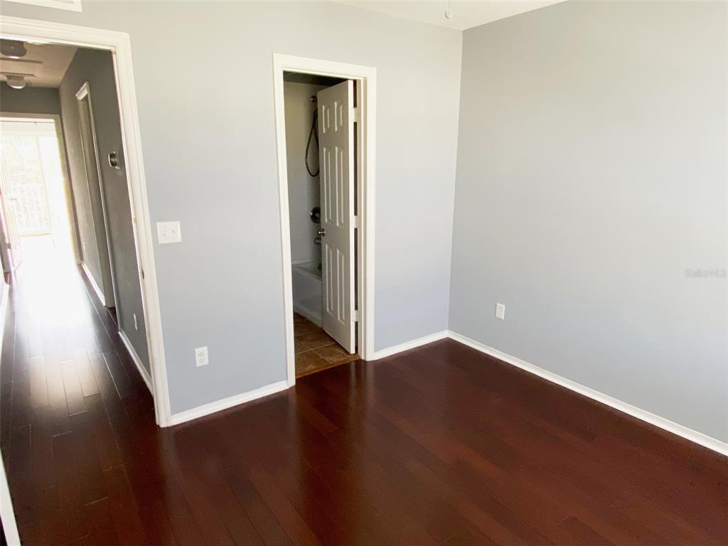 8946 White Sage Loop Lakewood Ranch, FL 34202 - Photo 28 of 36 an empty room with wooden floor and entrance