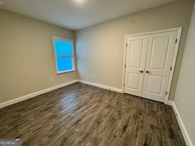 a view of an empty room with wooden floor