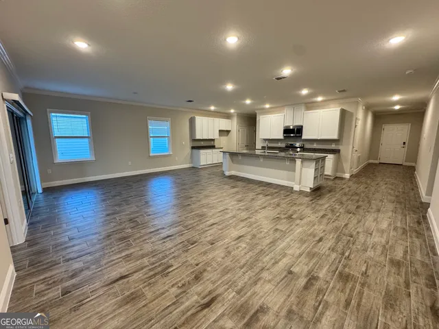 an open kitchen with kitchen island a sink dishwasher stove and wooden cabinets